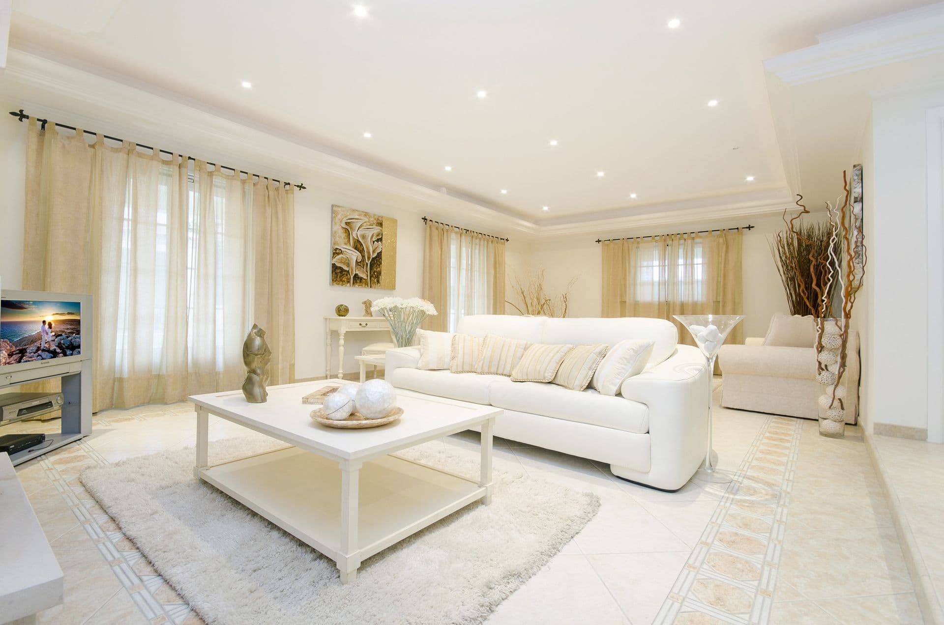 Sala de estar residencial de alto padrão com sofá e tapete claros